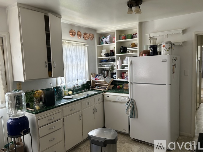 A kitchen with a white refrigerator and cabinets.