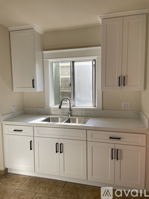 A kitchen with white cabinets and a sink.