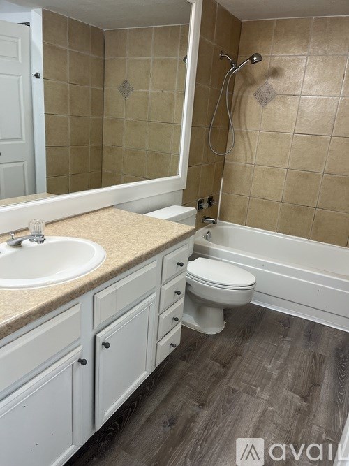A bathroom with a sink, toilet, and tiled walls.