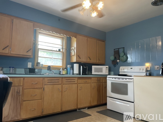 A kitchen with wooden cabinets and a white stove top oven.