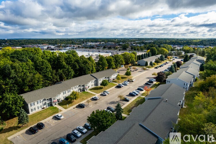 An aerial view of a parking lot with cars and buildings.
