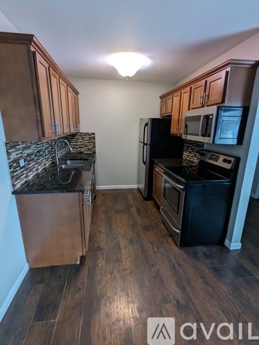 A kitchen with wooden cabinets and black appliances.