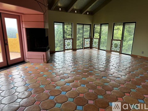 A living room with a television and a floor covered in hexagonal tiles.