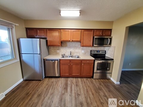 A kitchen with wooden floors and stainless steel appliances.