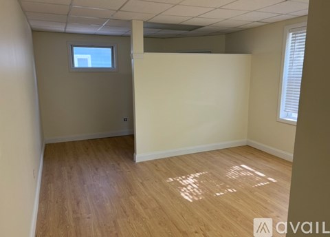 A room with wooden flooring and a window.