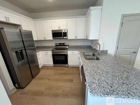 A kitchen with a granite countertop and stainless steel appliances.