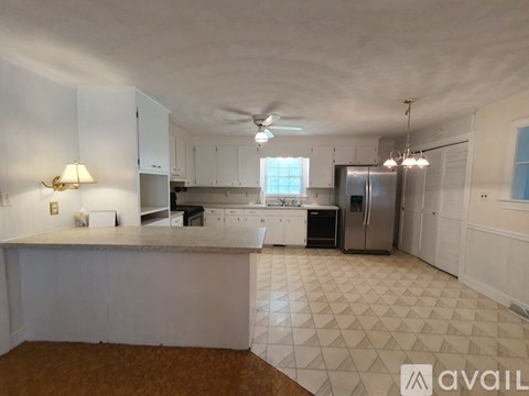 A kitchen with white cabinets and a tiled floor.