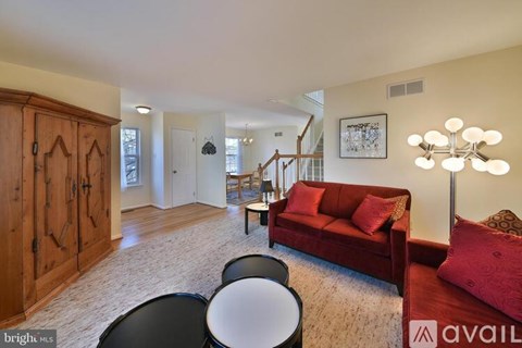 A living room with a red couch and a wooden cabinet.