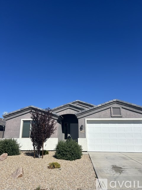 A gravel area in front of a house with a white garage door.