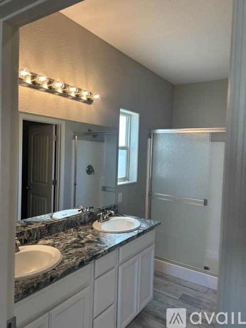 A bathroom with a toilet, sink, and mirror.