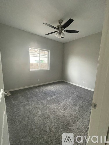 A room with a ceiling fan and a window.