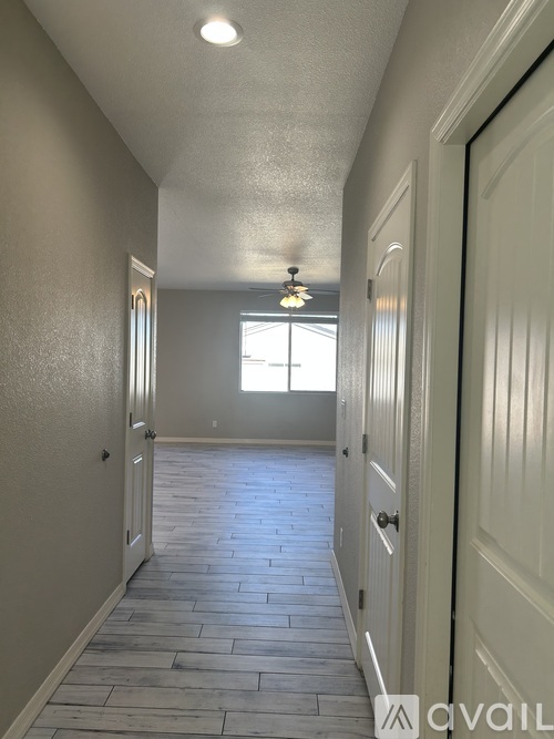 A long hallway with a tiled floor and white walls.