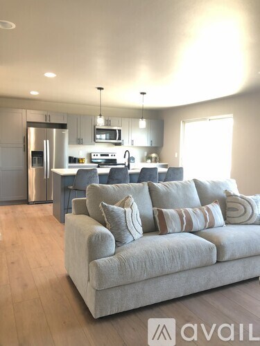 A modern living room with a couch and a kitchen in the background.