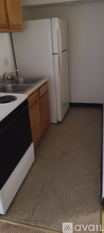 A kitchen with a white fridge and a white sink.
