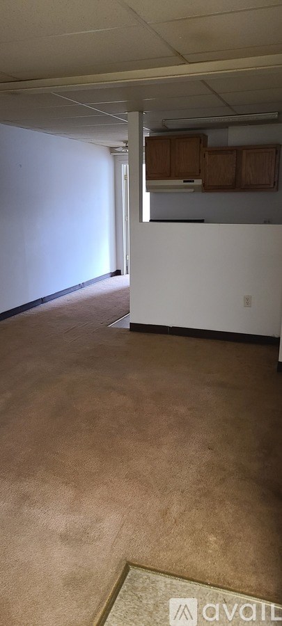 A room with a carpet and a wall with a logo on it.