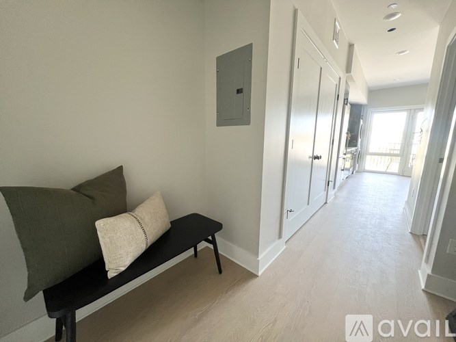 A long hallway with a bench and doors on the right.