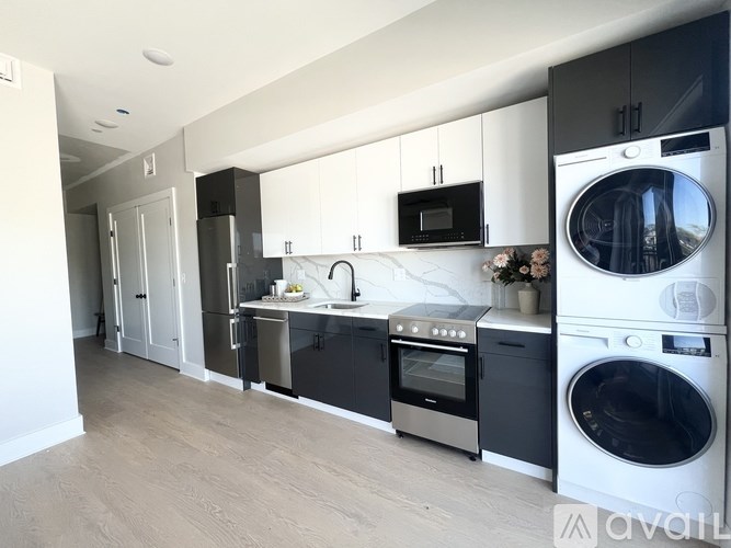 A modern kitchen with a washing machine and dryer built into the cabinetry.