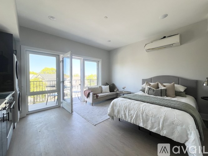 A bedroom with a large bed and sliding glass doors leading to a balcony.