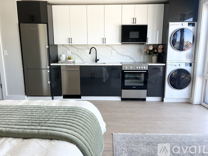 A modern kitchen with a refrigerator, oven, and washing machine.