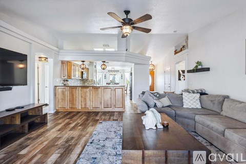 A living room with a grey couch and a wooden floor.