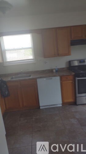 A kitchen with brown cabinets and a white dishwasher.