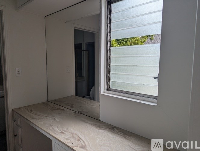 A bathroom with a window and a counter top.