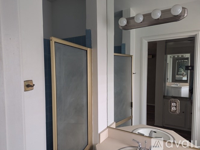 A bathroom with a mirror and a shower door.