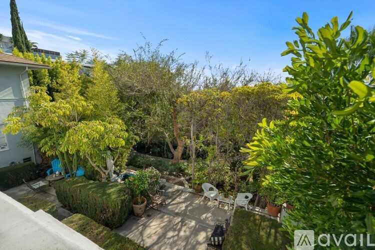 A backyard with a patio and a tree.