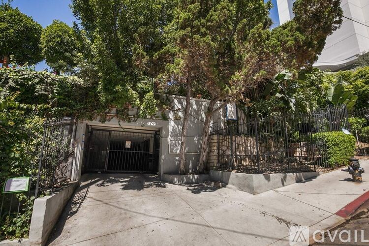 A concrete structure with a gate and a sign that says "available" in front of a tree.