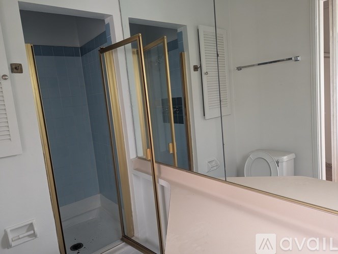 A bathroom with a glass shower door and a towel rack.
