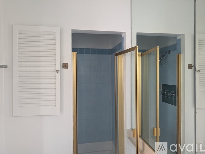 A bathroom with a white door and a glass shower door.