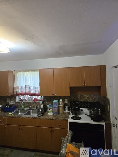 A kitchen with wooden cabinets and a stove top oven.
