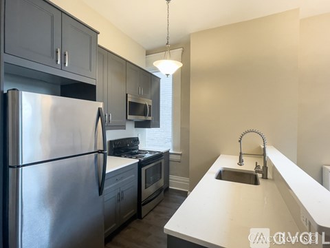A kitchen with a stainless steel refrigerator and a white countertop.