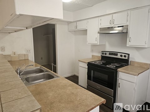 A kitchen with white cabinets and a black stove top oven.