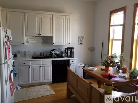 A kitchen with white cabinets and a refrigerator filled with magnets.