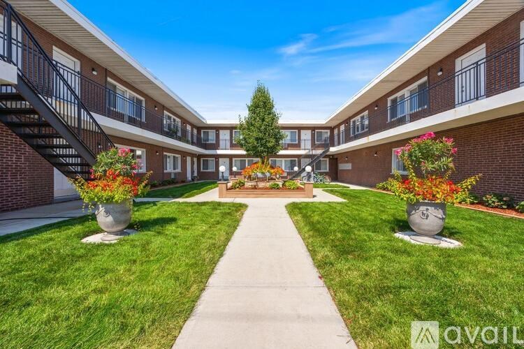 A sunny day at apartment complex with a central courtyard and flower pots.