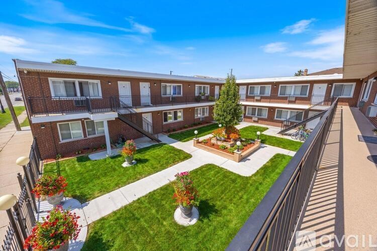 A sunny day at a brick apartment complex with a courtyard in the middle.