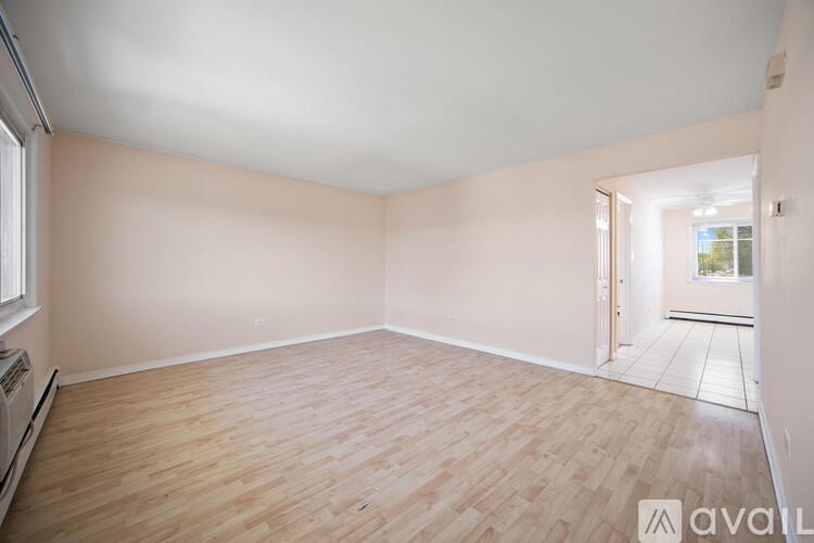 A room with wooden flooring and white walls.