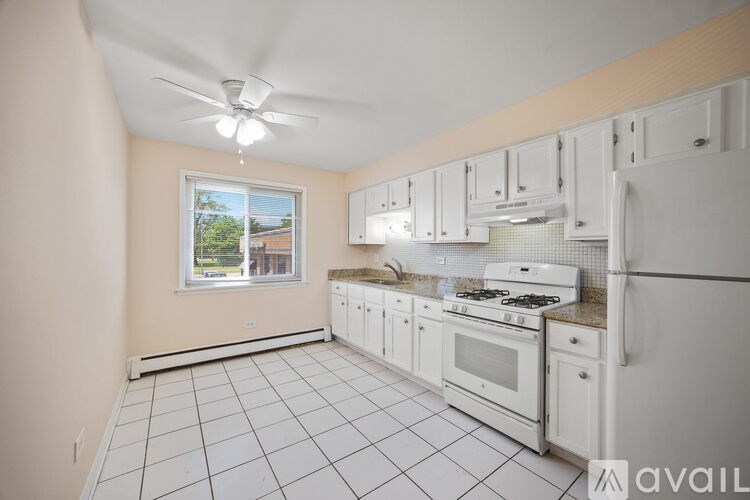 A kitchen with white appliances and cabinets is available for rent.