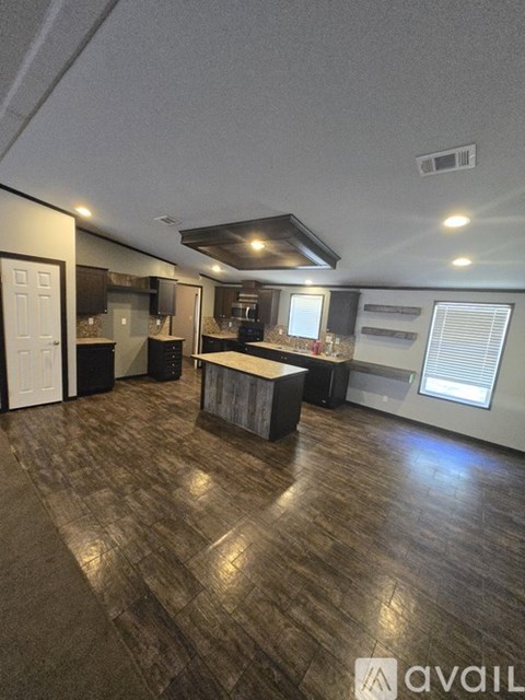 A spacious room with a kitchen area and a bar.