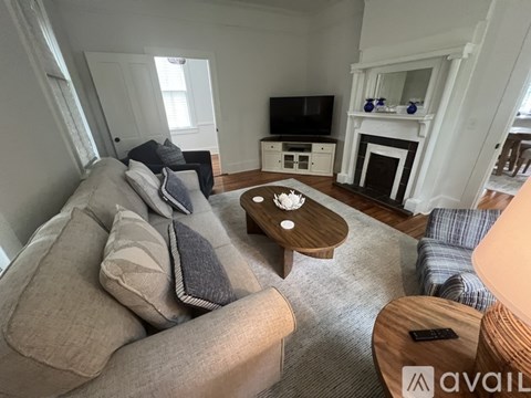 A living room with a grey couch and a wooden coffee table.