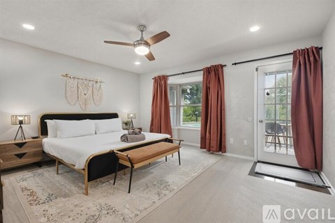 A bedroom with a large bed and a ceiling fan.