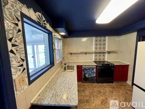 A kitchen with a black stove top oven and a refrigerator.
