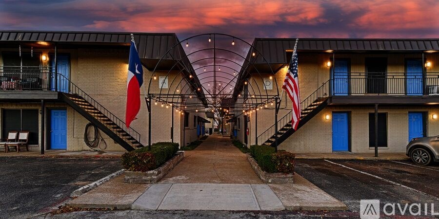 A hotel with a Texas flag and an American flag hanging on the balconies.
