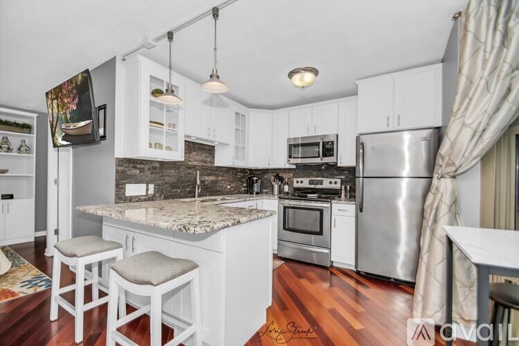 A kitchen with white cabinets and a granite countertop.