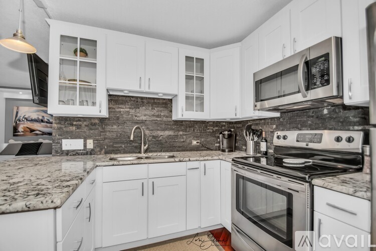 A kitchen with white cabinets and a granite countertop.