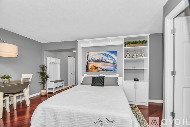 A bedroom with a large bed and a painting on the wall.