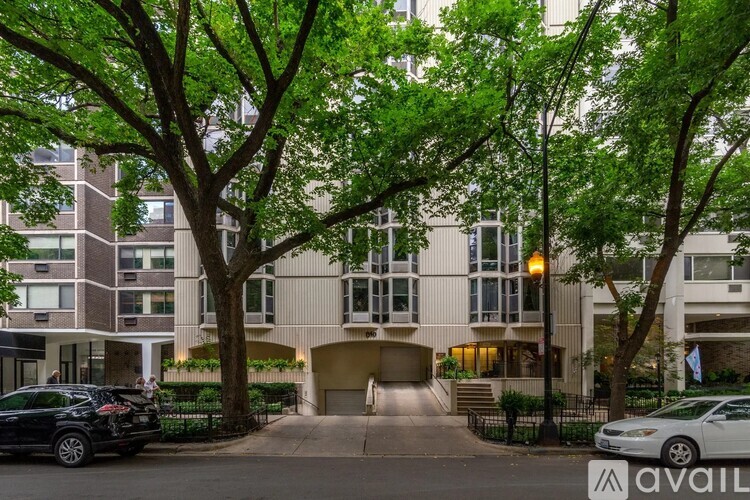 A building with a driveway and trees in front of it.
