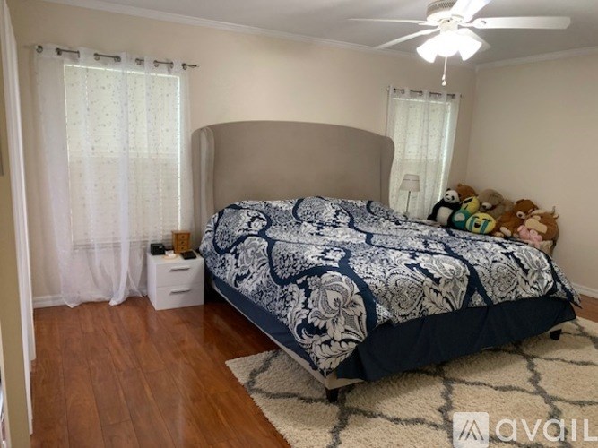 A bedroom with a large bed and a ceiling fan.