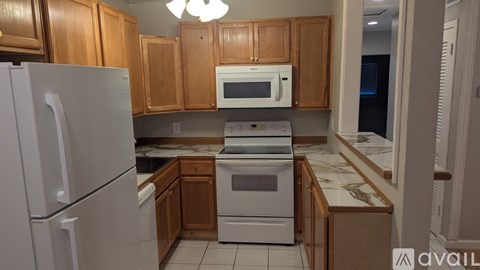 A kitchen with wooden cabinets and a white refrigerator.